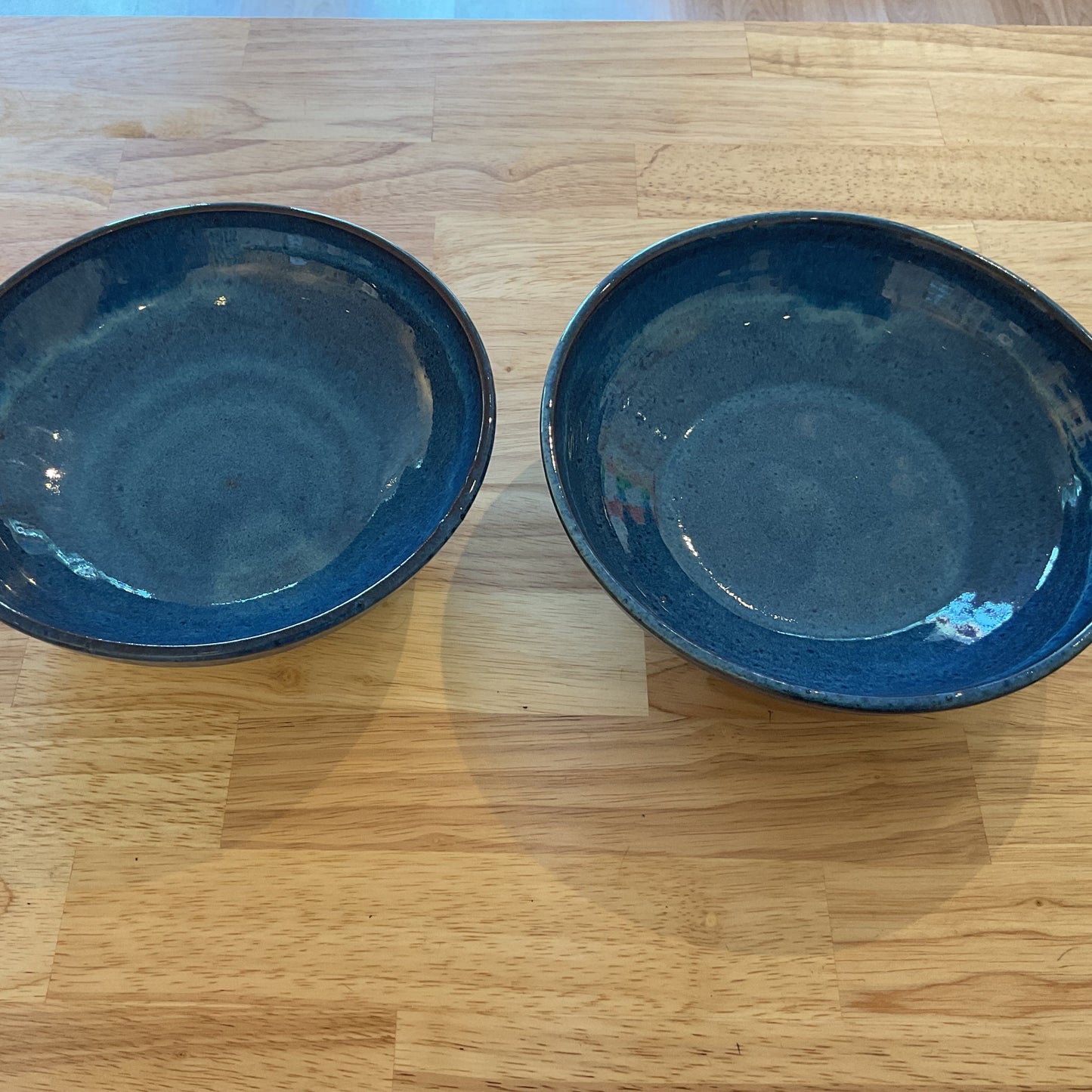 Two blue ceramic bowls on a wooden surface