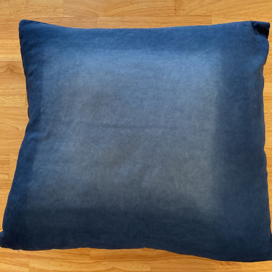 Blue pillow on a wooden floor