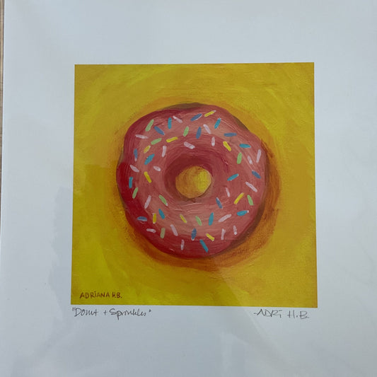 Framed artwork of a pink donut with sprinkles on a yellow background
