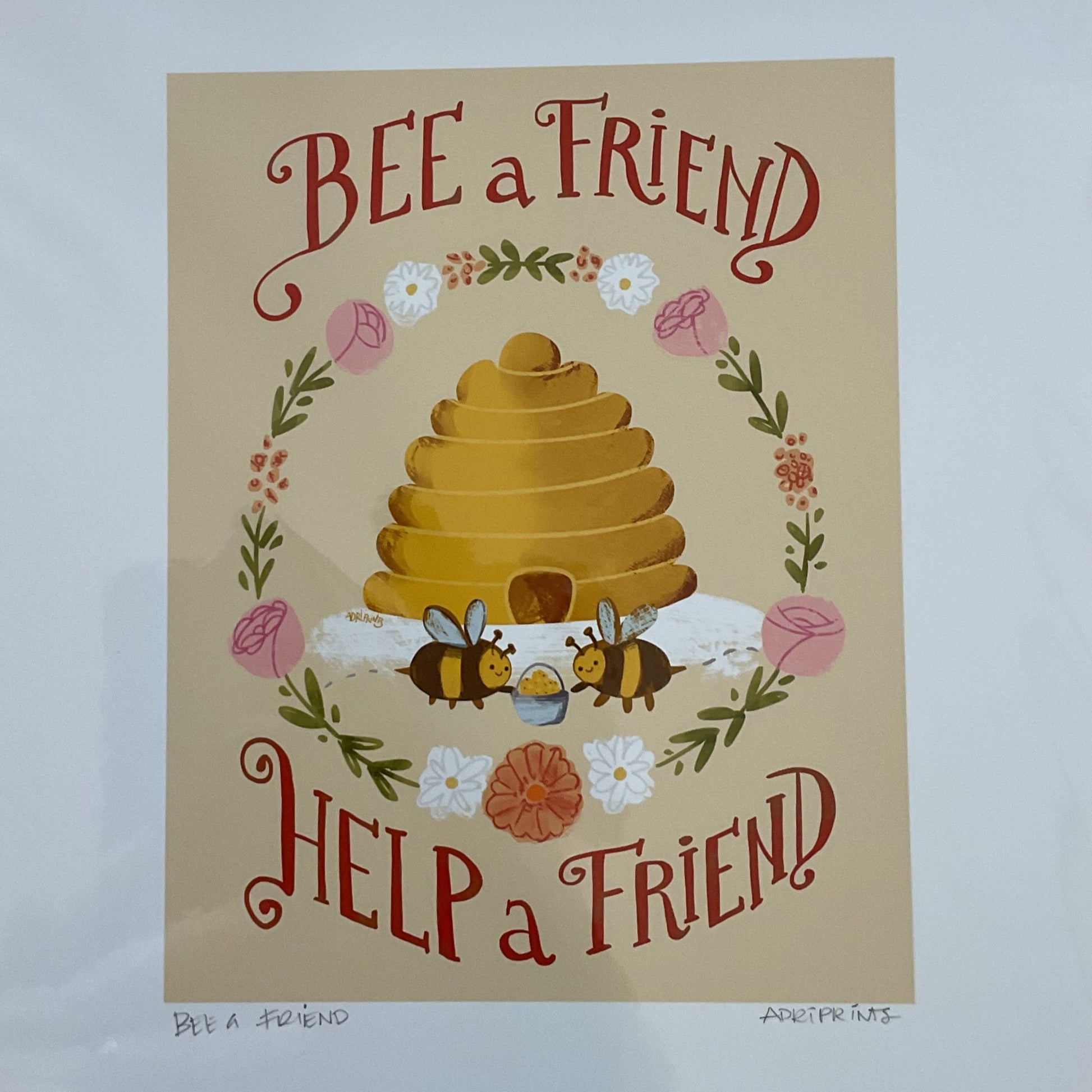 Poster with a bee hive and text 'BEE a FRIEND' and 'HELP a FRIEND' on a wooden surface.