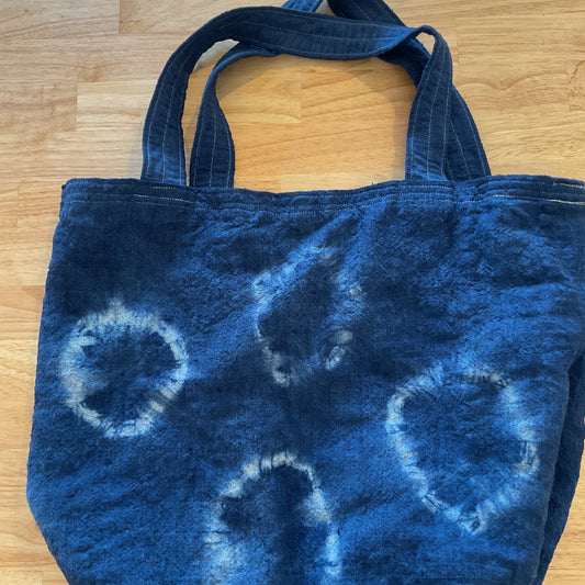 Blue tie-dye tote bag on a wooden surface