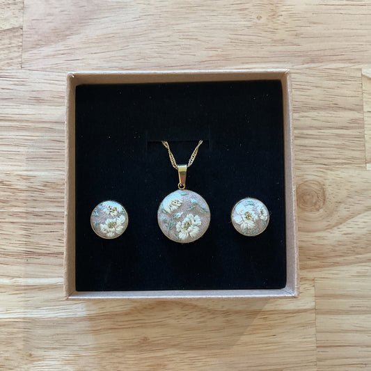 Jewelry set with pendant and earrings in a box on a wooden surface