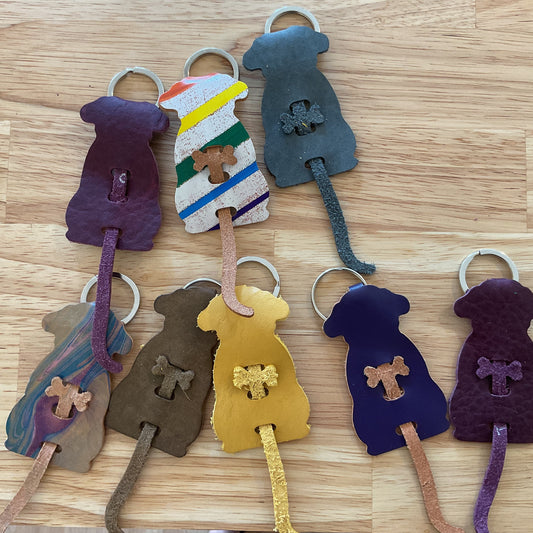 Set of colorful dog-shaped keychains on a wooden surface