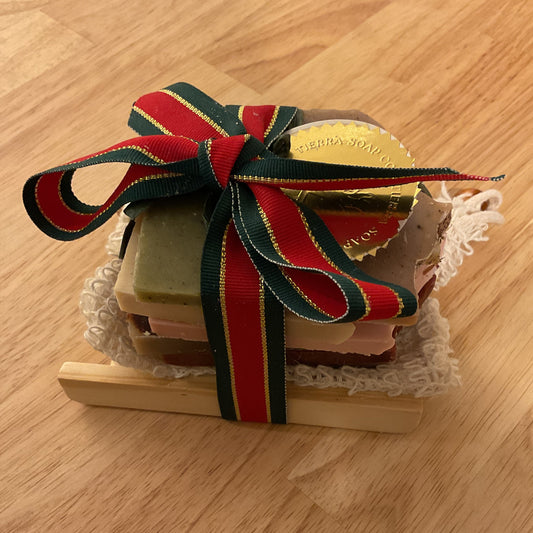 Small wooden box with a red and green ribbon on a wooden surface