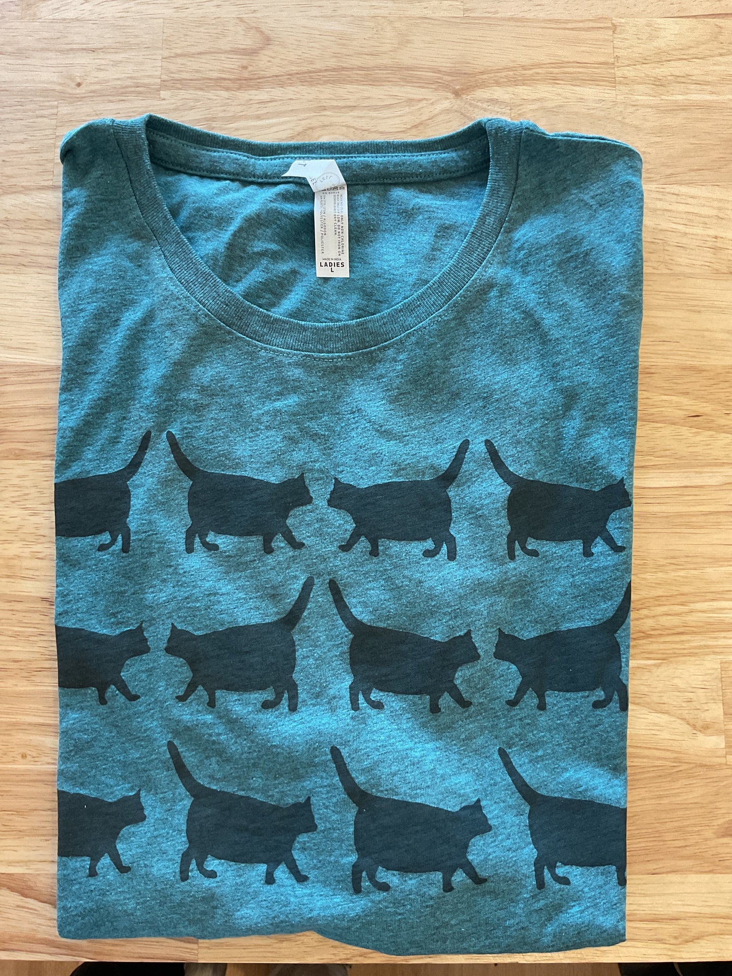 Blue t-shirt with black animal pattern on a wooden surface