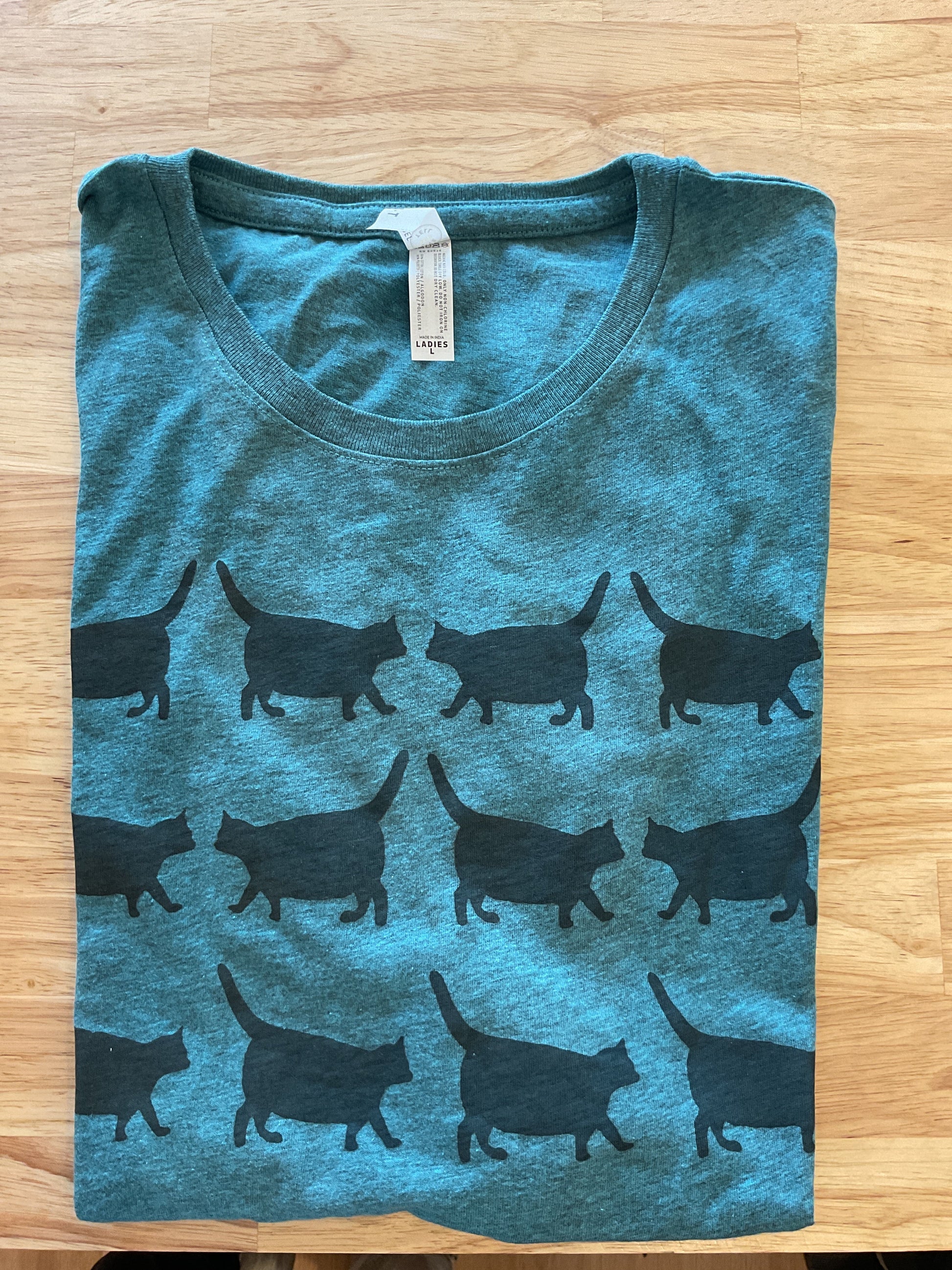 Blue t-shirt with black animal pattern on a wooden surface