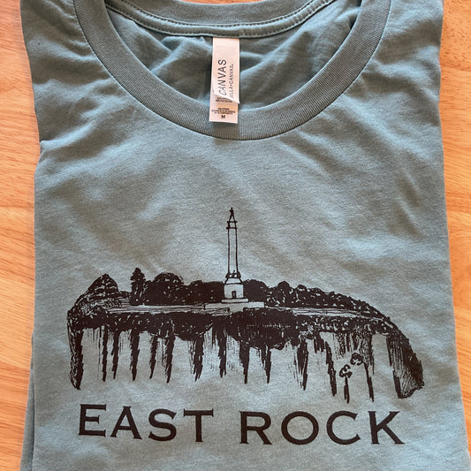 Gray t-shirt with 'East Rock' graphic design on a wooden surface